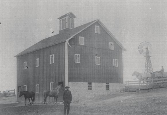 Above: Jesse Ashton, the founder of the Ashton Farmstead/ Kelley Family Farm, stands proudly in front of his magnificent barn that will serve the Ashton/Kelley family for 150 years to come.