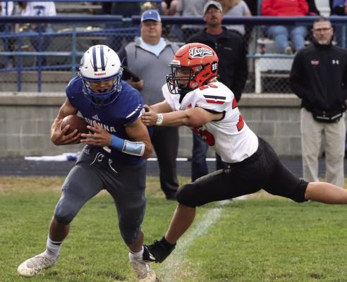 Cambridge’s Adam Corbett brings down the Ravenna quarterback Friday night.