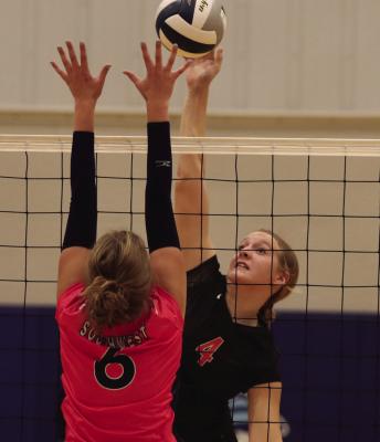 Cambridge’s Brylyn Springer tips an attack over the blocking hands of Southwest’s Kyra Nelms.