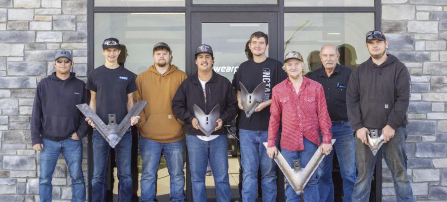 NCTA Advanced Welding students and faculty visit WearParts in Gothenburg, where students learned about hard-surfacing processes used to extend the life of agricultural tillage equipment. Students are pictured with examples of tillage components produced at the facility. From left to right: WearParts Operations Manager, Justin Bliven, Advanced Welding Students: Talon Carter, William Cockroft, Angel Rios, Tanner Hansen, Charlie Houser, Instructor Dan Stehlik, and Robbie Miller.