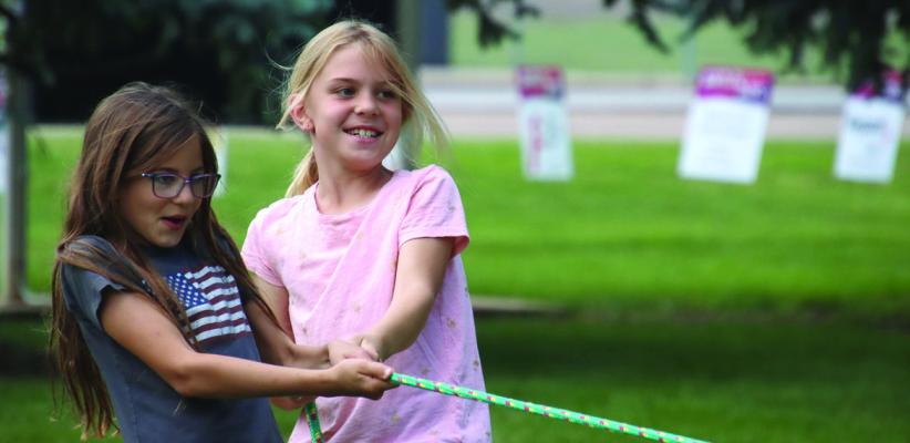 Two children work together to win a round of tug of war as part of the afternoon activities offered.