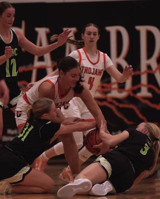Maywood-Hayes Center’s Ava Messersmith and Paytyn Stengel tie up Cambridge’s Mallory Springer on a loose ball.