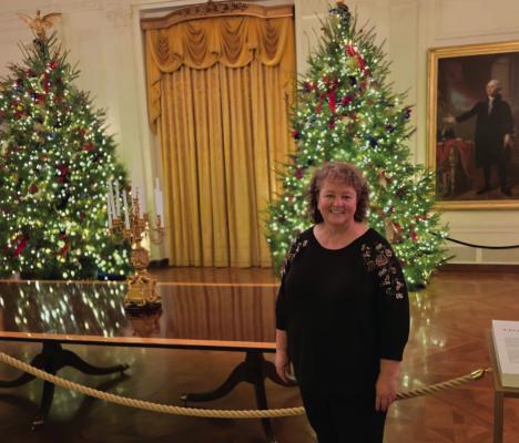 Cambridge’s Michelle Shifflet was one of 150 volunteers selected to decorate the White House over Thanksgiving weekend. She’s pictured in the East Room of the White House, where she pent a great deal of lighting and decorating the live 16-foot trees behind her.