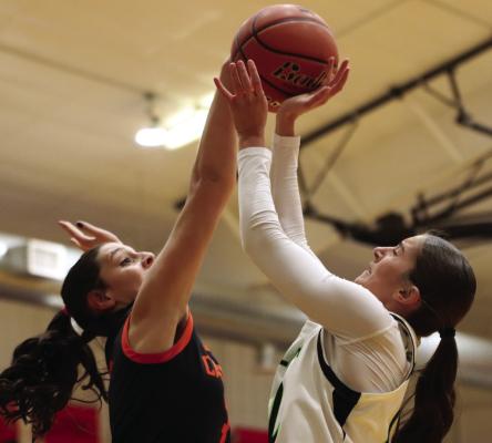 The Trojans’ Mallory Springer rejects the shot of the Wolves’ Blayklee Farr.