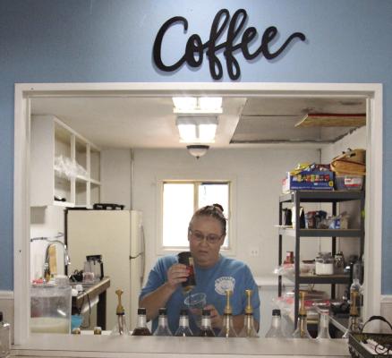 Owner of KimBean, Kim Connolly, makes a drink in the open kitchen window.