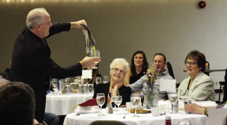 Entertainer Mike Bliss seemingly pours orange juice from a newspaper while an astonished crowd looks on during the Golden Generation Center Gala “A Magical Night” on April 6 in Oxford.
