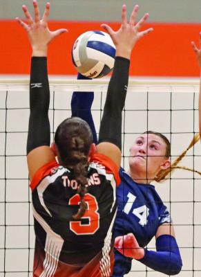 Southwest’s Atleigh Nelms slams an attack past the block of Cambridge’s Mallory Springer during the championship match of the Cambridge Invite Saturday.
