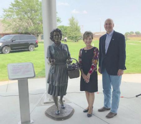 Artist Sondra Johnson and Pete Ricketts stand by the bronze sculpture of a WWII Canteen Lady at the Norfolk Veterans Home.