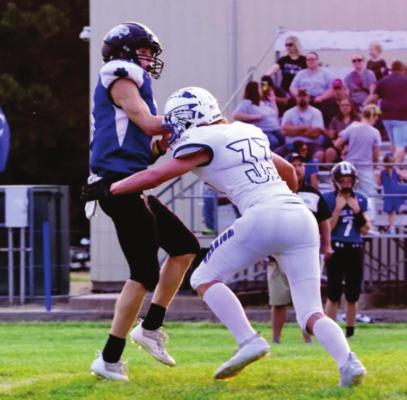 Arapahoe’s Gabe White lays the boom to the Blue HIll quarterback on a throw Friday night.