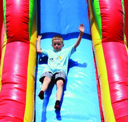 A child of Bartley slides down one of the two bounce houses offered in the park.