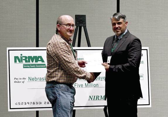 Gosper County Receives Dividend Check NIRMA Board of Directors member Erich Tiemann (right) presents a dividend check to Gosper County Highway Superintendent Michael Snyder (left).