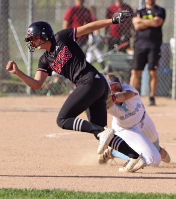 Southern Valley/Alma’s Brynn Baily reaches to try and tag a straying Cozad baserunner during a subdistrict contest Monday. the Saints saw their season come to a close with a loss to Cozad. Story on Page B2.