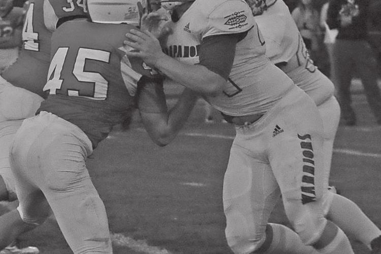 Arapahoe’s Triston Abraham blocks on the edge of the line.