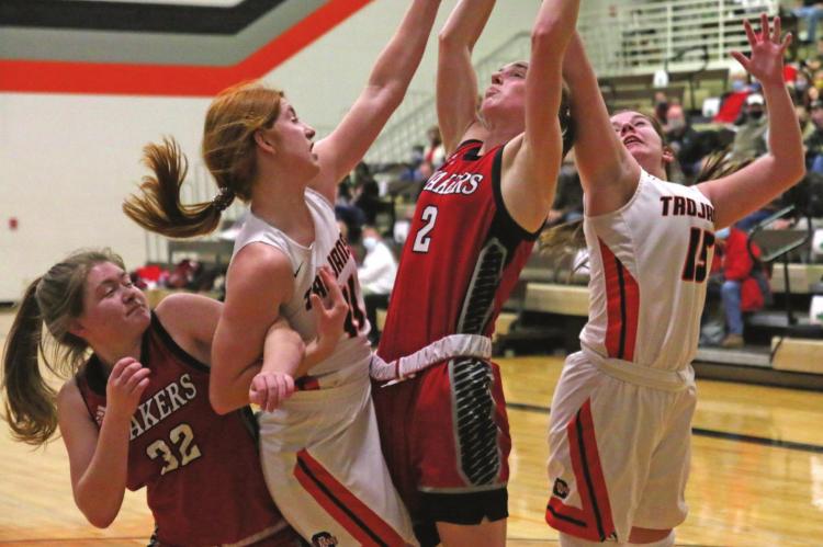Cambridge’s Autumn Deterding and Carsyn Hanes battle a pair of Caoxad players for a rebound Thursday.